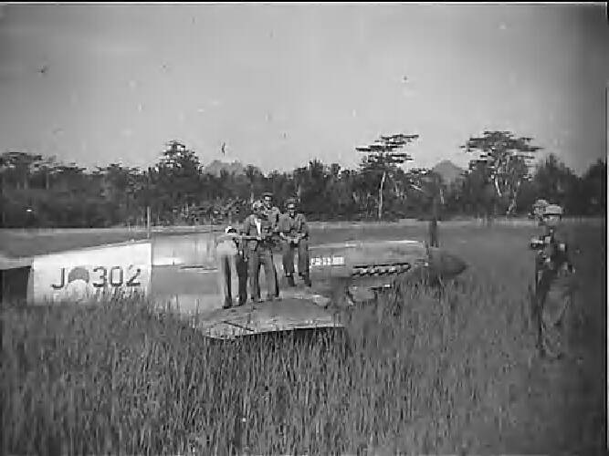 Militairen staan gezamenlijk boven op een Curtiss P40N Kittyhawk jachtvliegtuig …